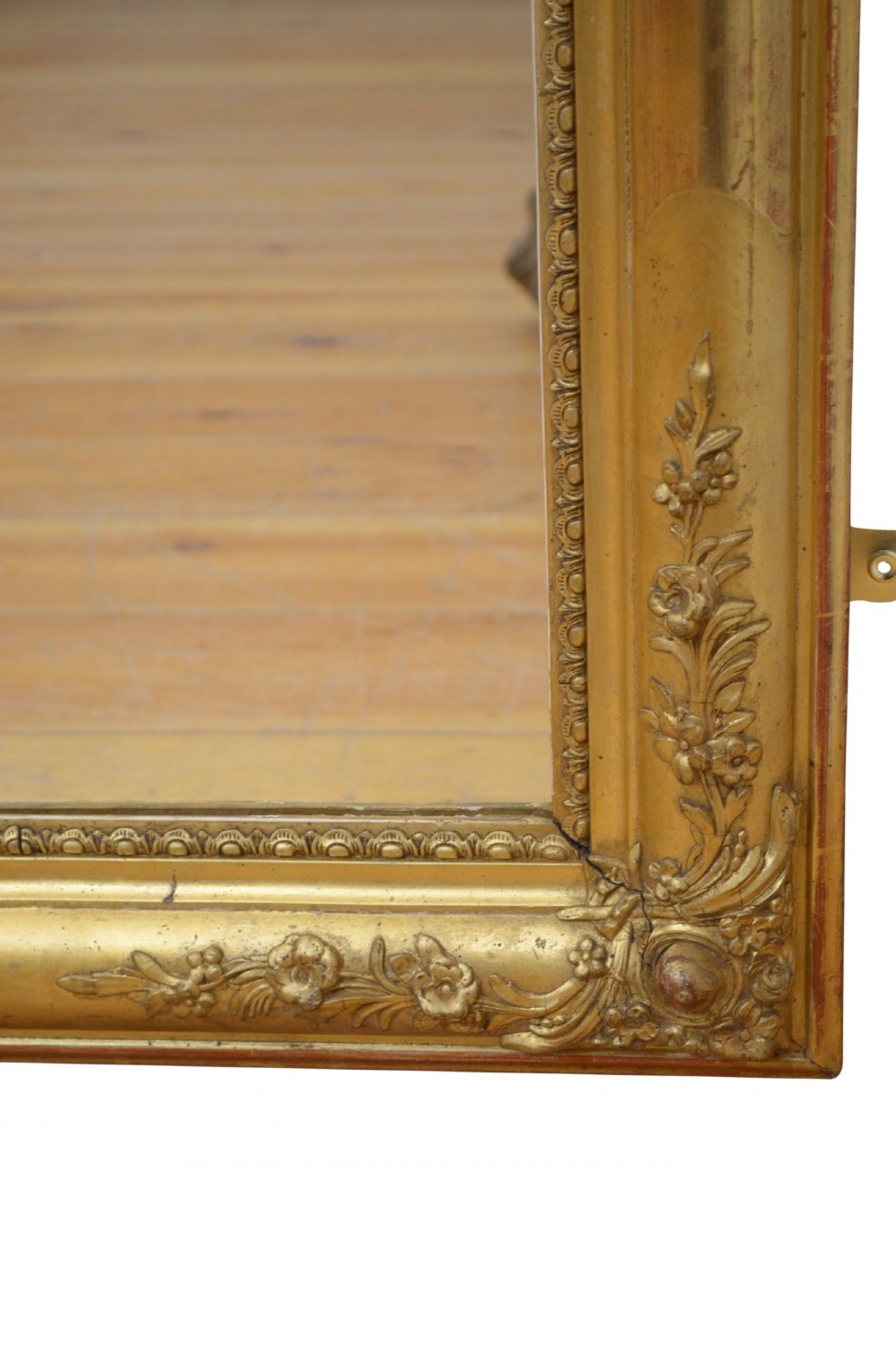 A large rectangular antique giltwood wall mirror with carved floral corner details and a beaded inner border. View VII