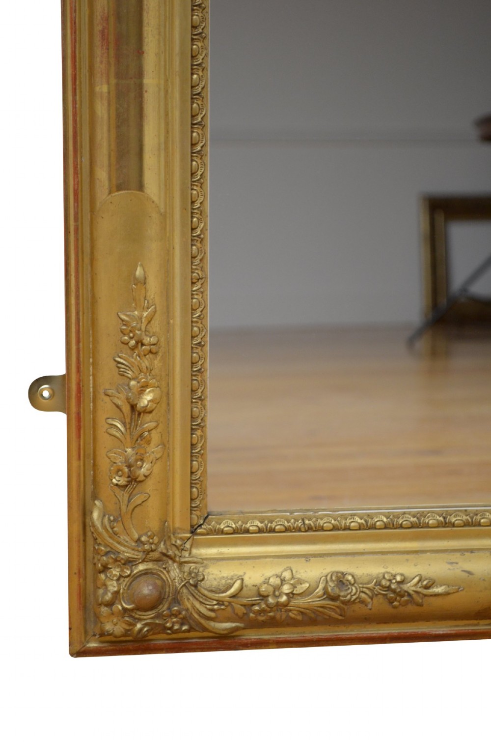 A large rectangular antique giltwood wall mirror with carved floral corner details and a beaded inner border. View XII
