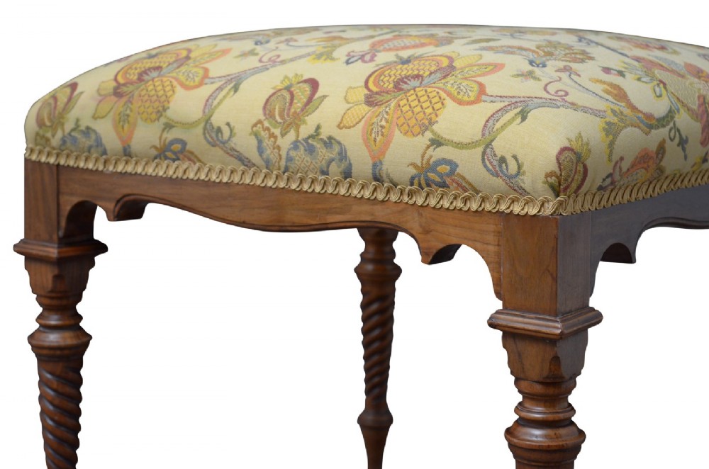 A walnut dressing table stool with turned barley twist legs and a padded seat upholstered in yellow floral patterned fabric. View IV