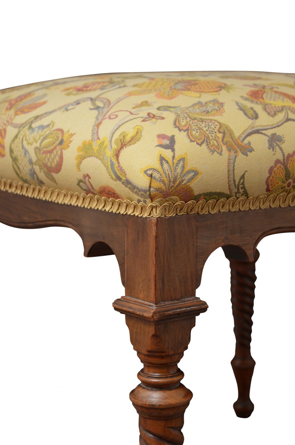 A walnut dressing table stool with turned barley twist legs and a padded seat upholstered in yellow floral patterned fabric. View VI