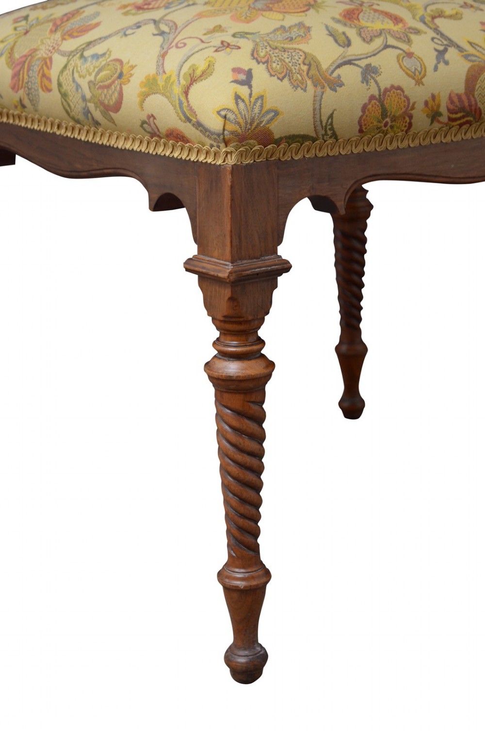 A walnut dressing table stool with turned barley twist legs and a padded seat upholstered in yellow floral patterned fabric. View VII