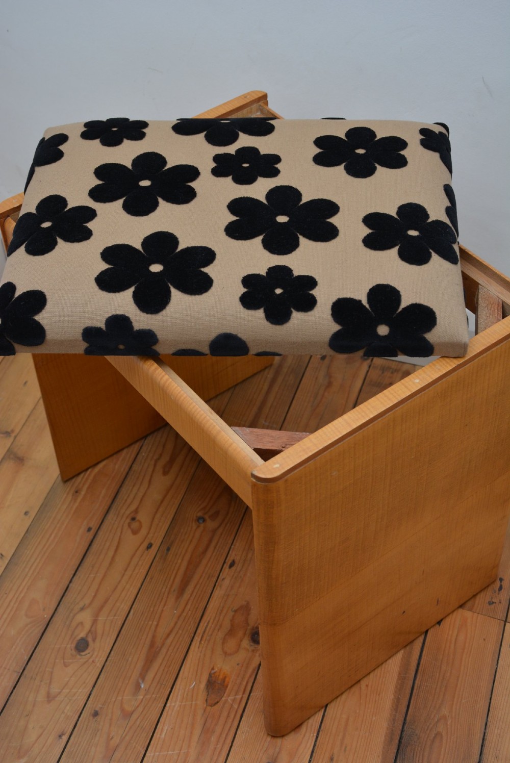 An Art Deco sycamore wood dressing stool featuring slab side legs, a low cylindrical stretcher, and a padded seat upholstered in beige fabric with black floral motifs. View VIII