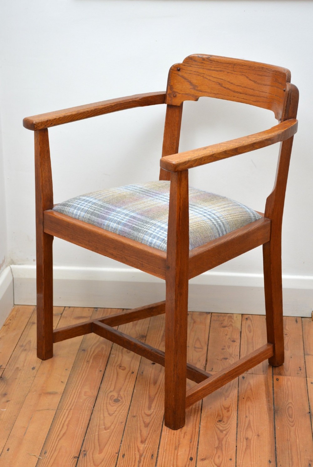 An oak Arts and Crafts desk chair featuring straight armrests, a rectangular backrest, and a blue and grey plaid upholstered seat. View II