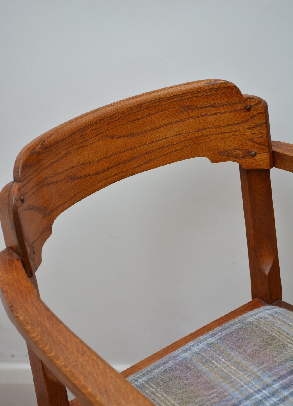 An oak Arts and Crafts desk chair featuring straight armrests, a rectangular backrest, and a blue and grey plaid upholstered seat. View IV