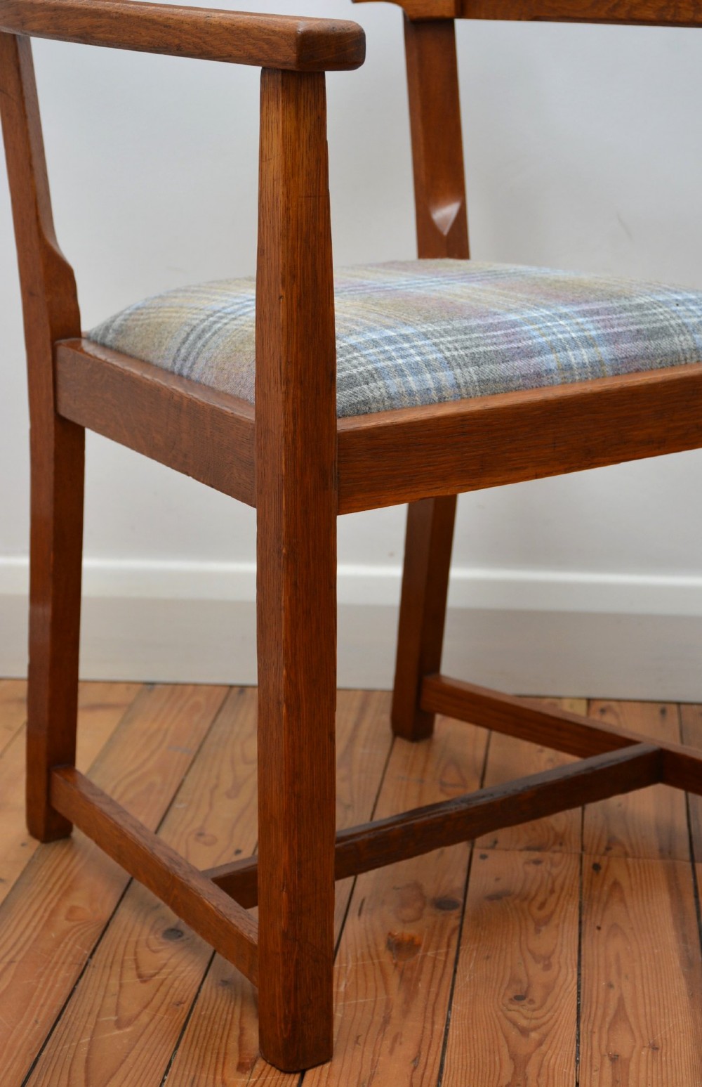 An oak Arts and Crafts desk chair featuring straight armrests, a rectangular backrest, and a blue and grey plaid upholstered seat. View VII
