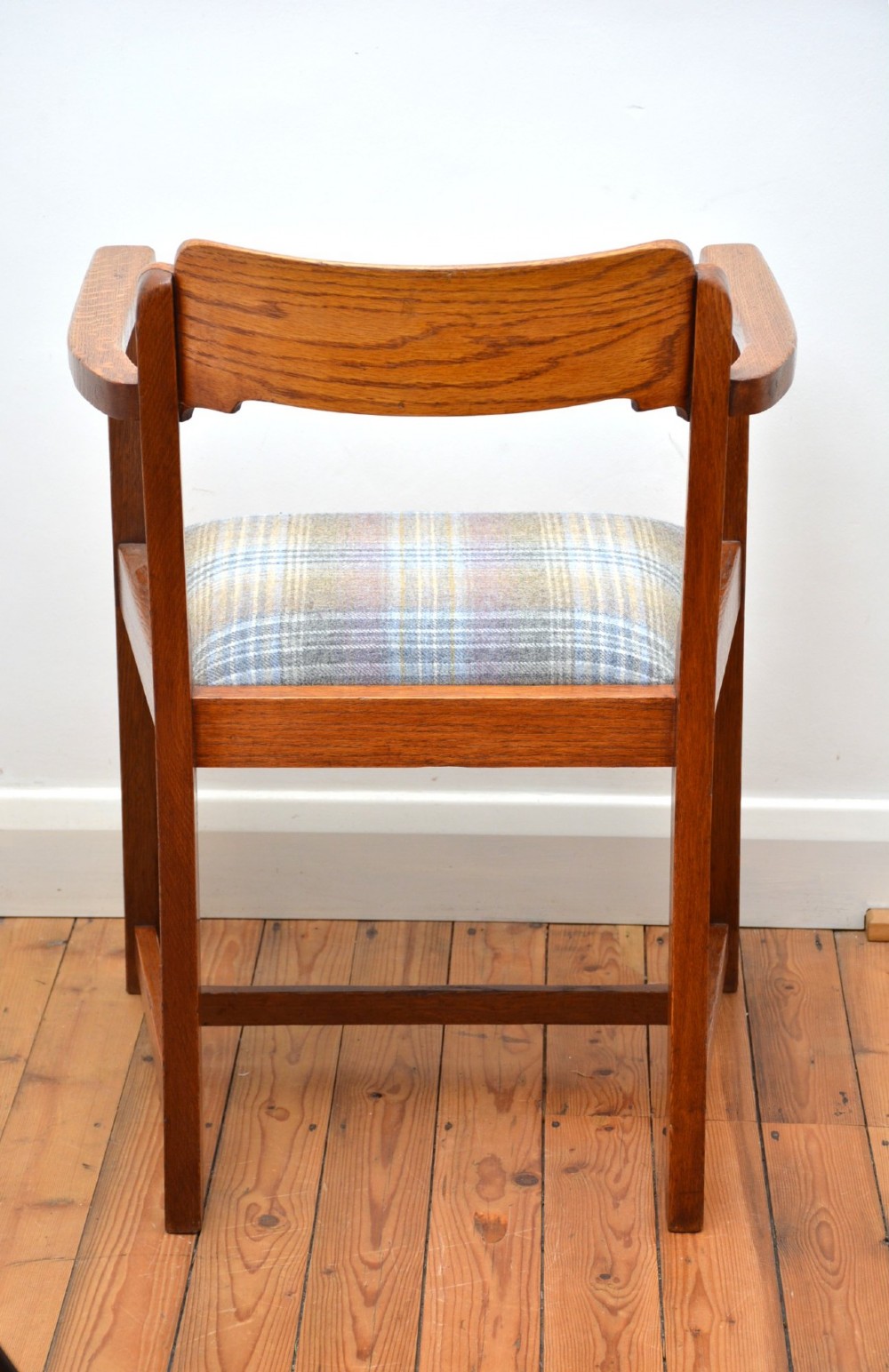 An oak Arts and Crafts desk chair featuring straight armrests, a rectangular backrest, and a blue and grey plaid upholstered seat. View XII