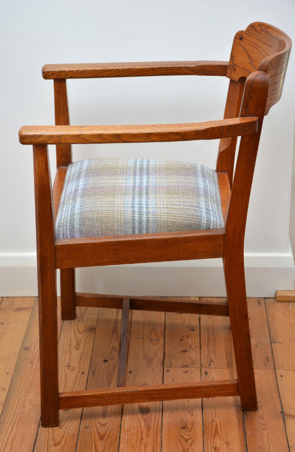 An oak Arts and Crafts desk chair featuring straight armrests, a rectangular backrest, and a blue and grey plaid upholstered seat. View XIII