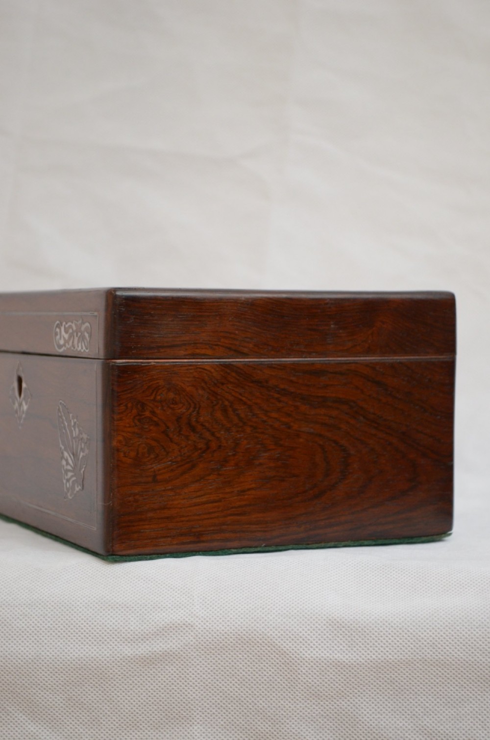 A rectangular dark rosewood jewellery box featuring brass foliate inlays and a central brass keyhole escutcheon. View II