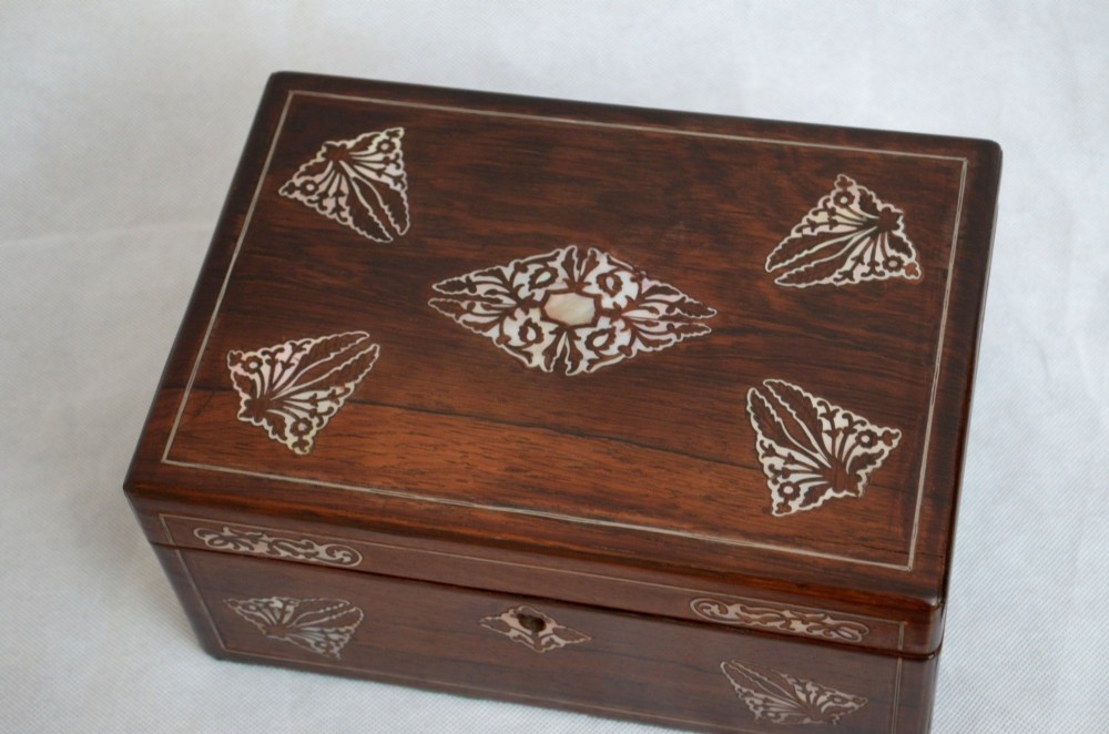 A rectangular dark rosewood jewellery box featuring brass foliate inlays and a central brass keyhole escutcheon. View V