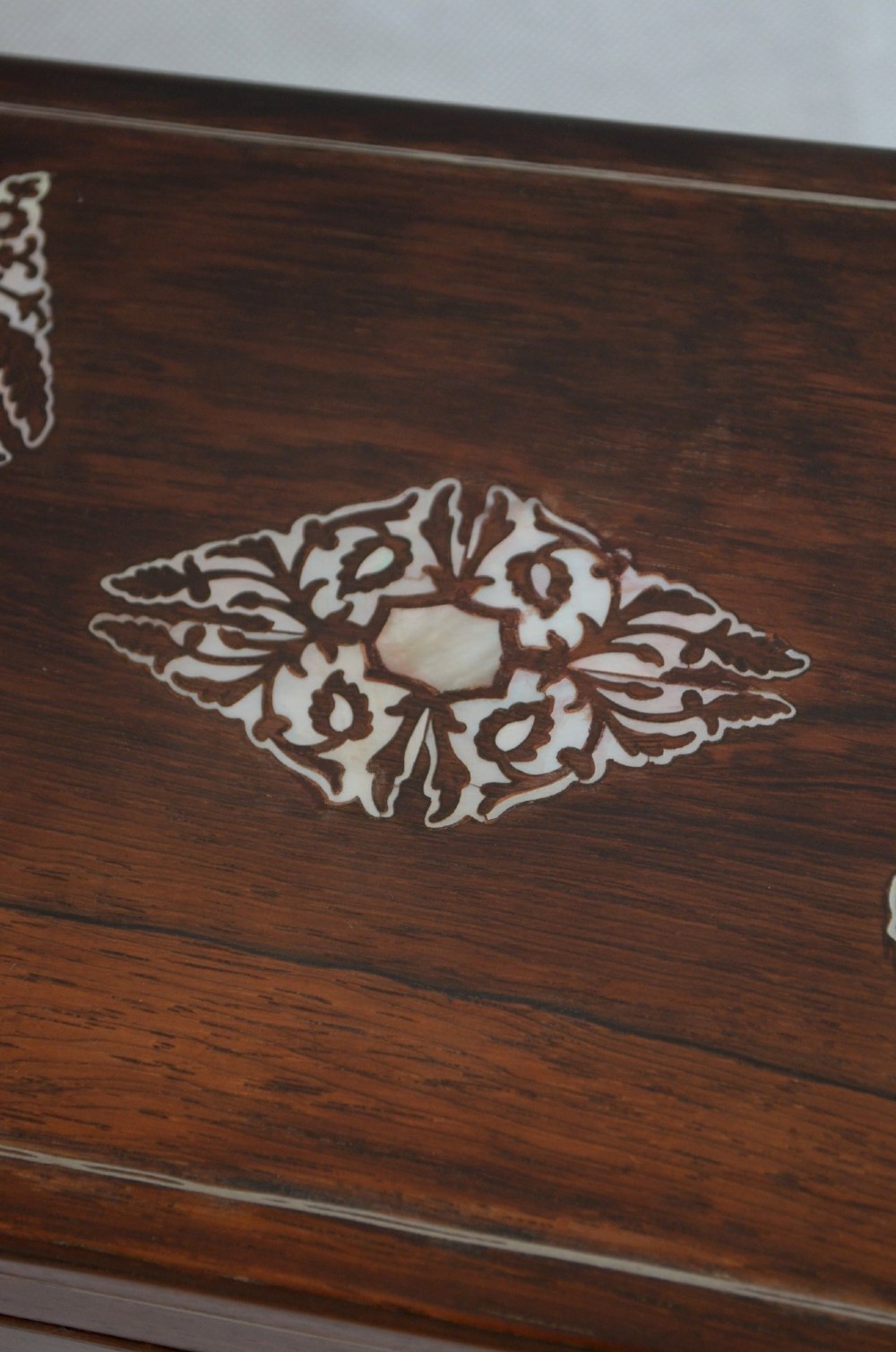 A rectangular dark rosewood jewellery box featuring brass foliate inlays and a central brass keyhole escutcheon. View VI