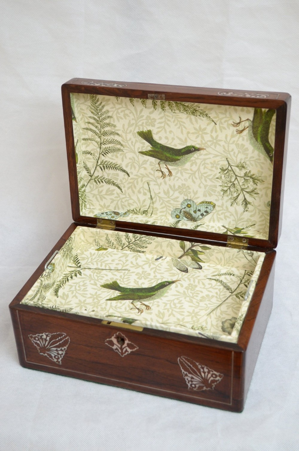 A rectangular dark rosewood jewellery box featuring brass foliate inlays and a central brass keyhole escutcheon. View VIII