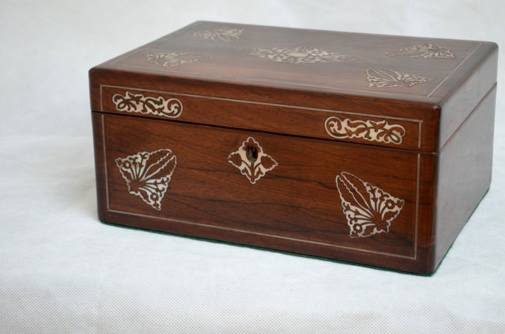 A rectangular dark rosewood jewellery box featuring brass foliate inlays and a central brass keyhole escutcheon. View X