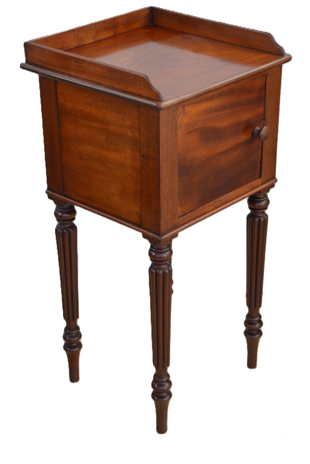 A dark mahogany bedside cabinet featuring a three-sided gallery top, a single door with a turned wooden knob, and four slender reeded legs. View II