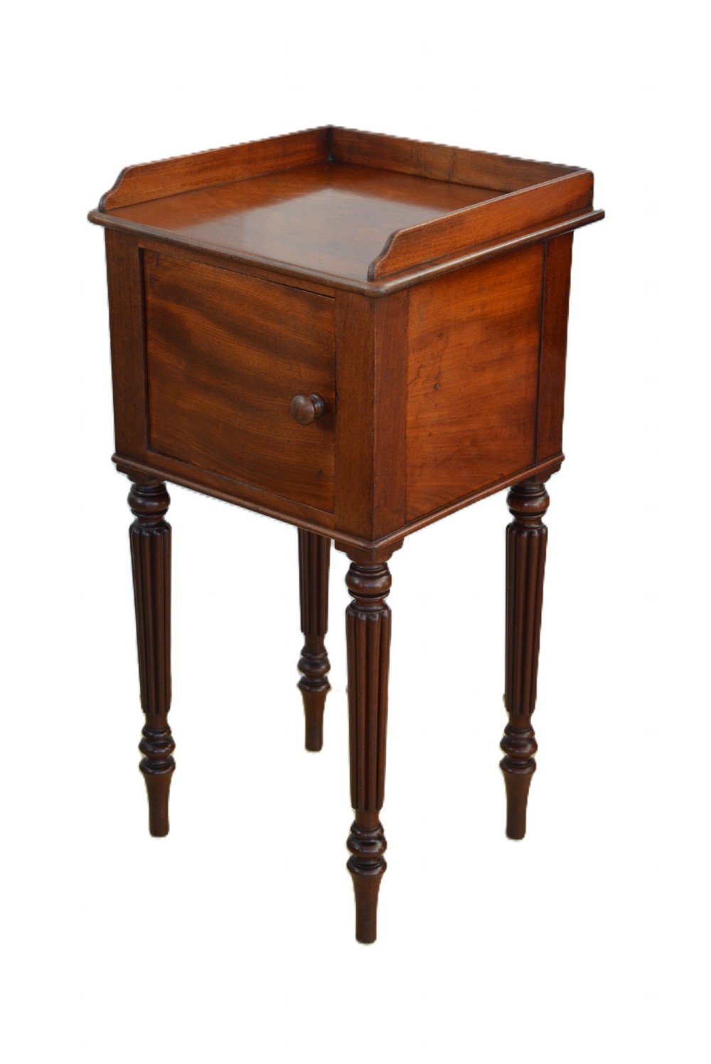 A dark mahogany bedside cabinet featuring a three-sided gallery top, a single door with a turned wooden knob, and four slender reeded legs. View III