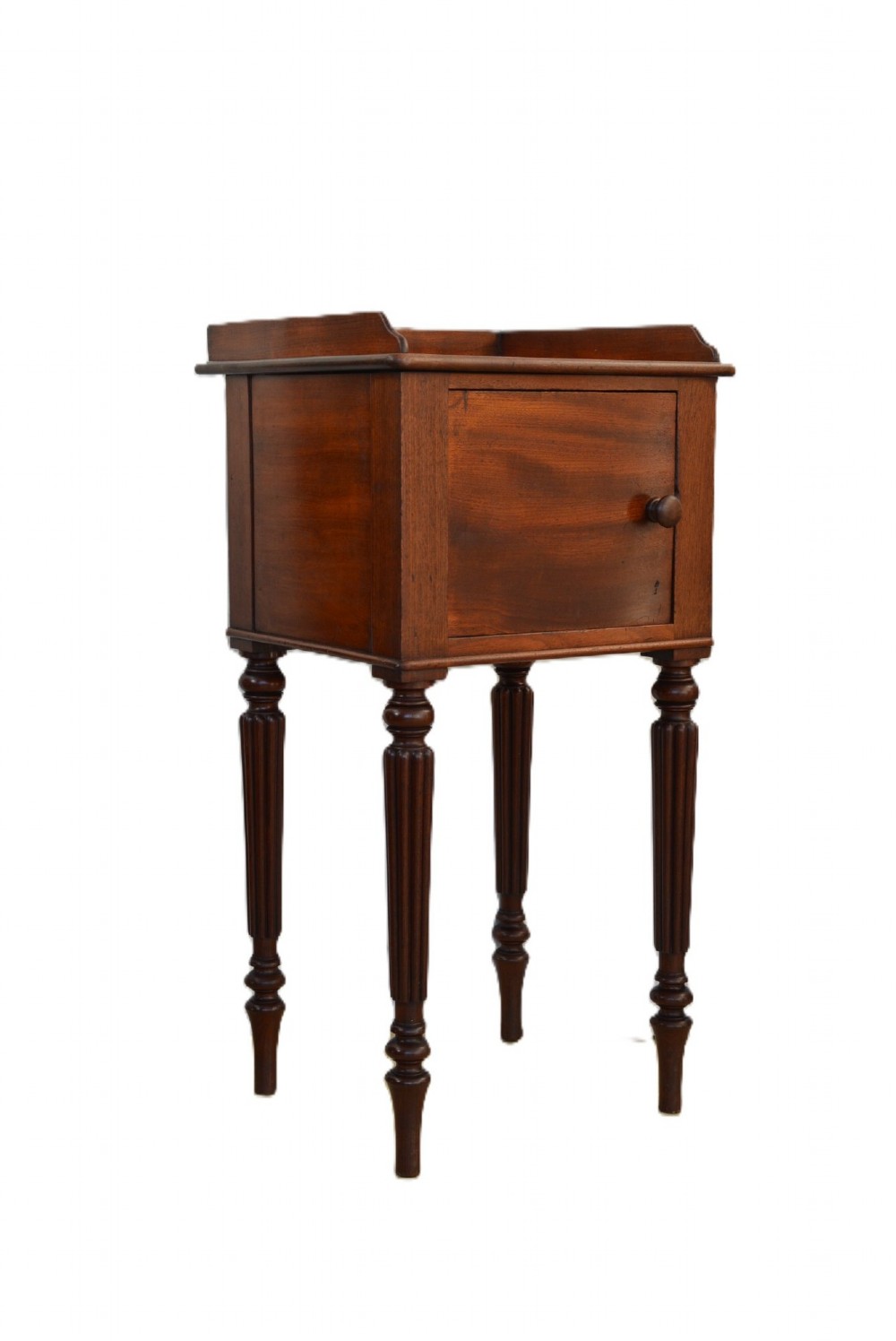A dark mahogany bedside cabinet featuring a three-sided gallery top, a single door with a turned wooden knob, and four slender reeded legs.