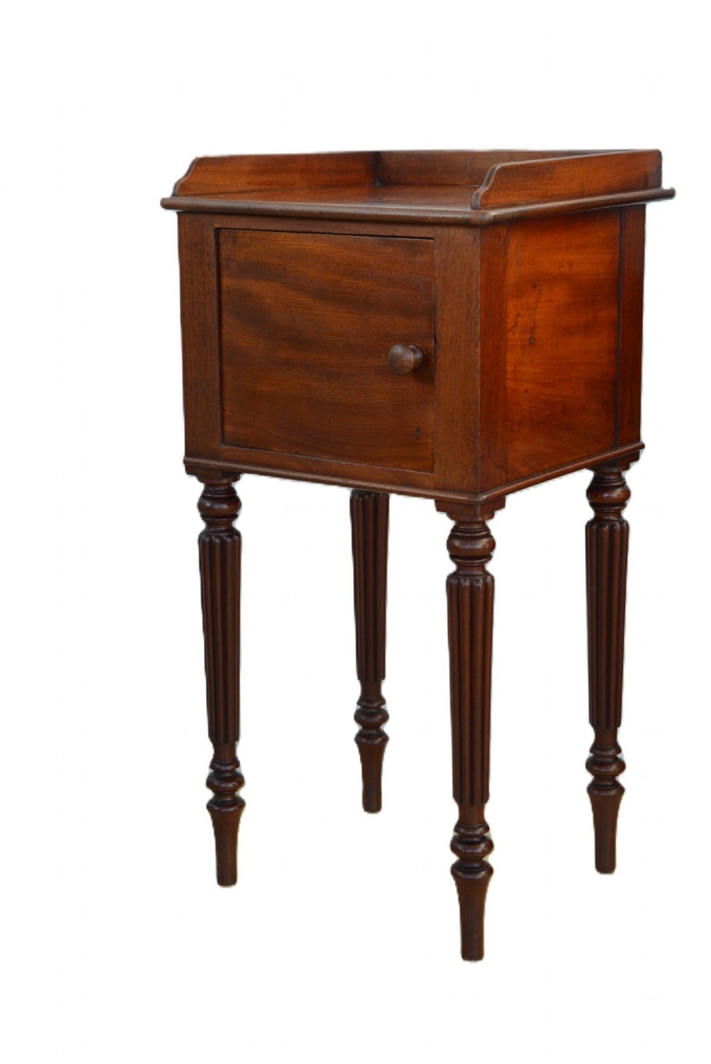 A dark mahogany bedside cabinet featuring a three-sided gallery top, a single door with a turned wooden knob, and four slender reeded legs. View V