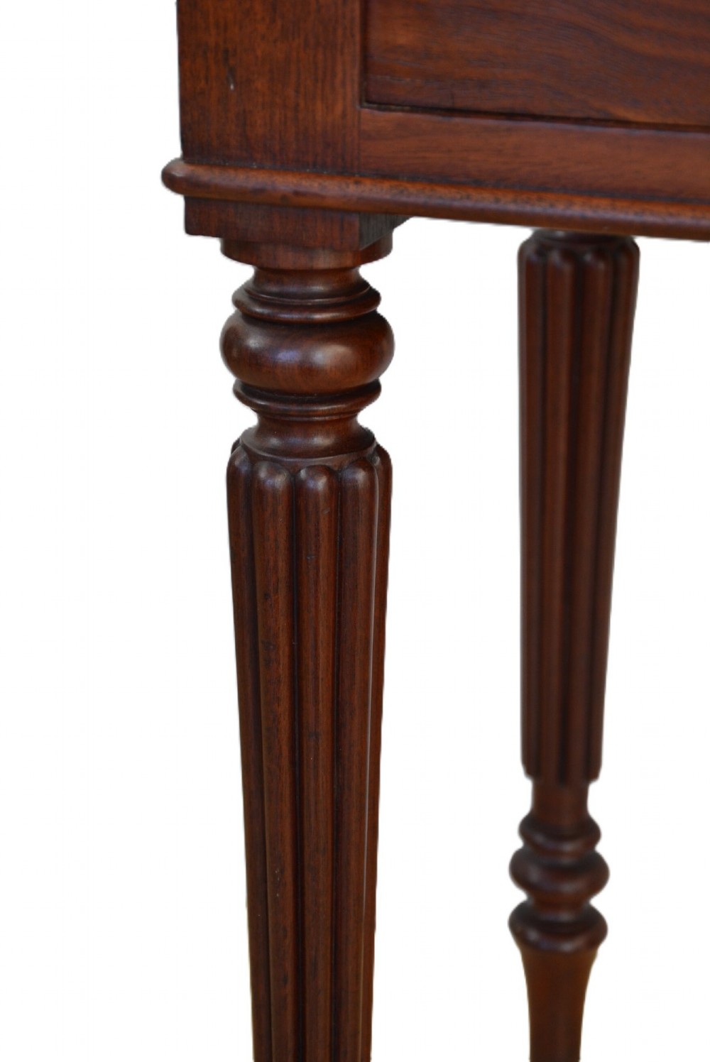 A dark mahogany bedside cabinet featuring a three-sided gallery top, a single door with a turned wooden knob, and four slender reeded legs. View XII