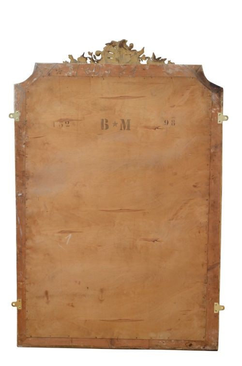 A tall antique giltwood wall mirror featuring an ornate carved floral cresting at the top, decorative foliate moulding along the frame, and original glass. View VII