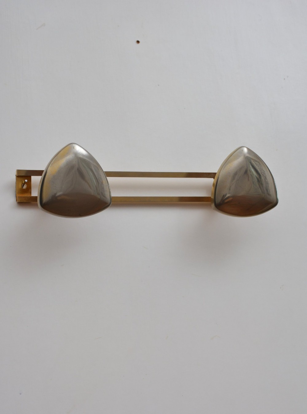 A set of two silver shield-shaped coat hooks mounted on a horizontal gold-toned metal wall bar. View II