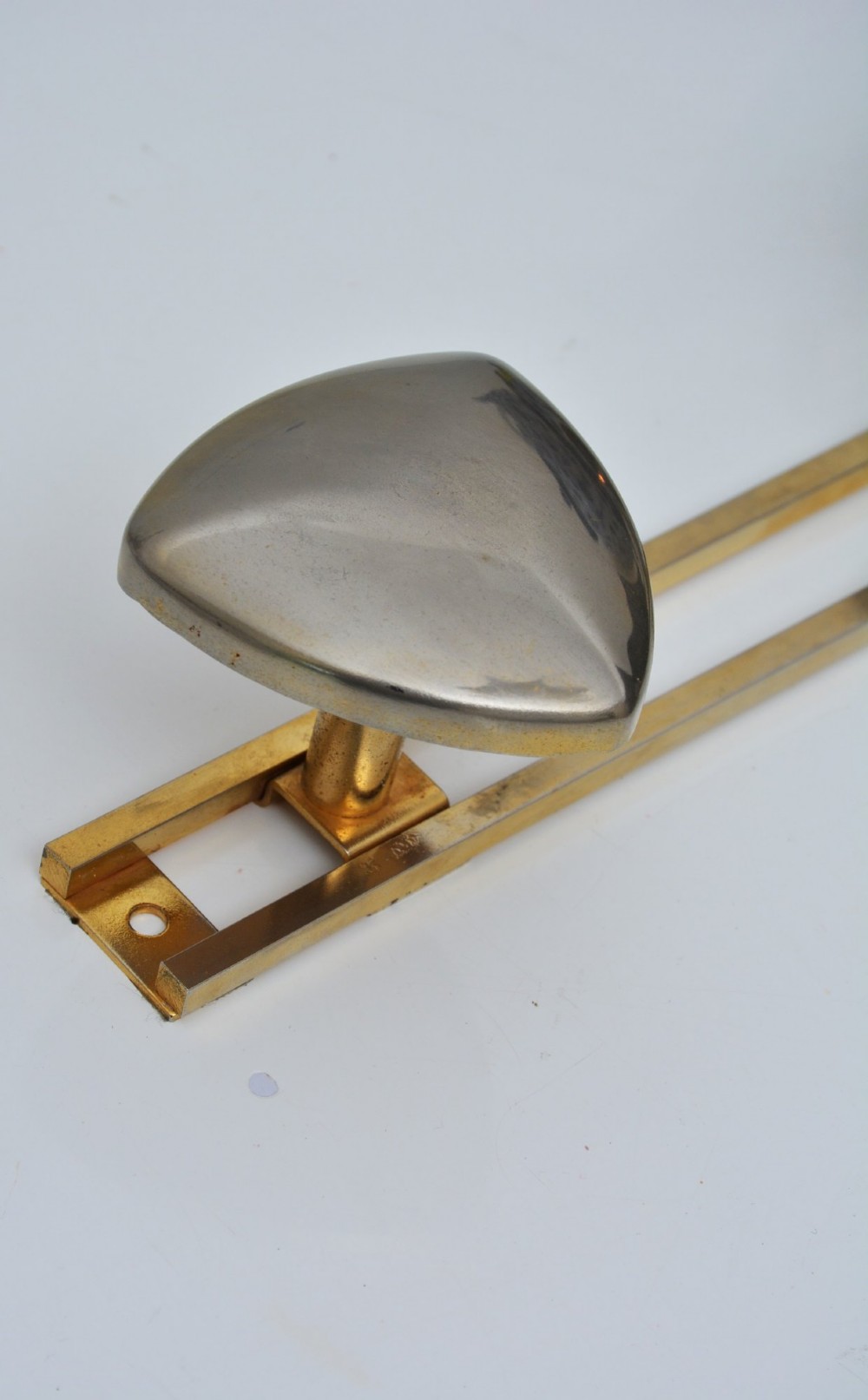 A set of two silver shield-shaped coat hooks mounted on a horizontal gold-toned metal wall bar. View VI