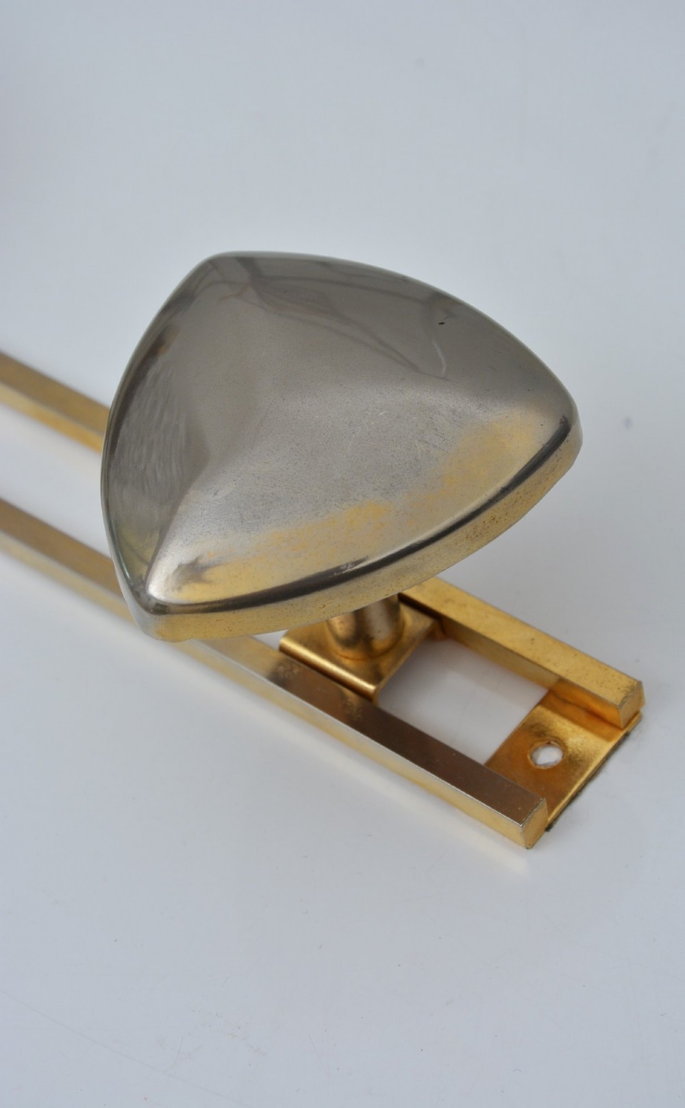 A set of two silver shield-shaped coat hooks mounted on a horizontal gold-toned metal wall bar. View VII