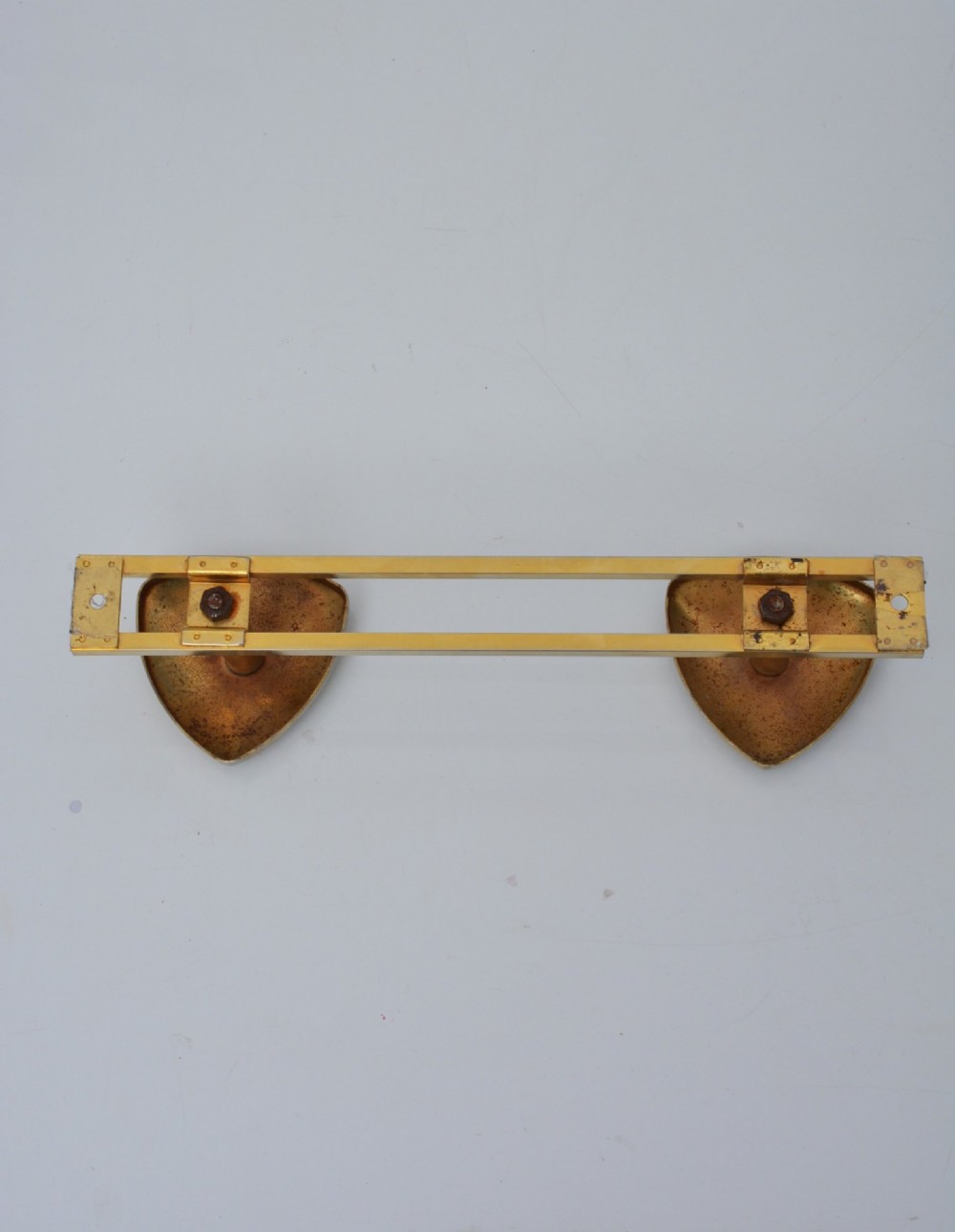 A set of two silver shield-shaped coat hooks mounted on a horizontal gold-toned metal wall bar. View IX
