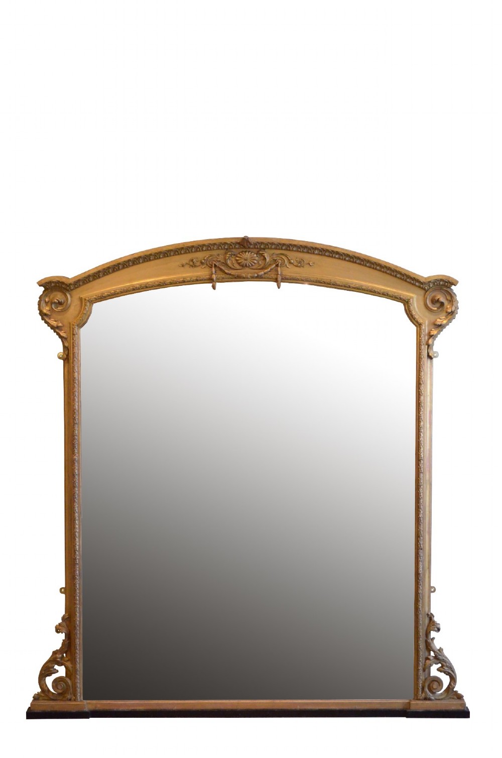 A large arched giltwood overmantel mirror featuring decorative floral moulding and side scroll details.