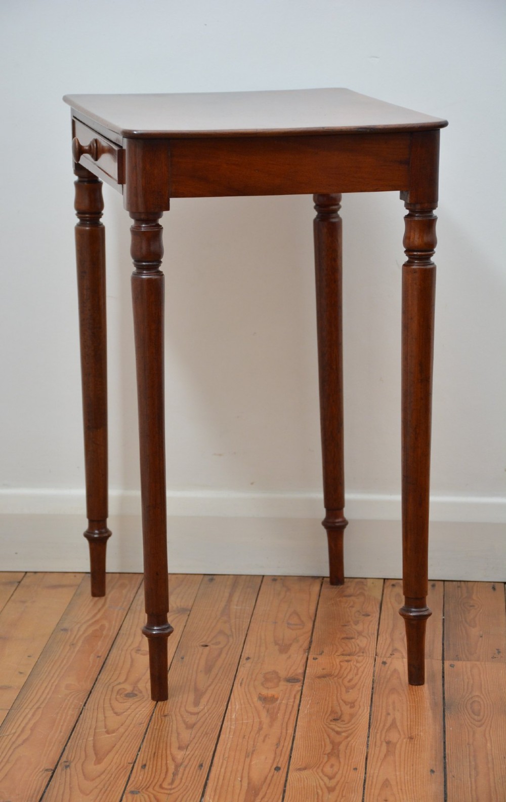 An English William IV mahogany side table featuring a single frieze drawer with a turned wooden knob handle and slim turned legs. View III