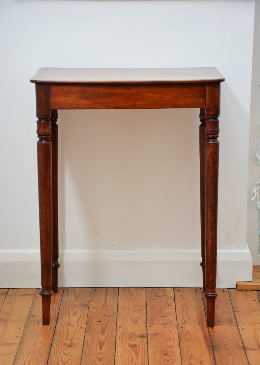 An English William IV mahogany side table featuring a single frieze drawer with a turned wooden knob handle and slim turned legs. View IV