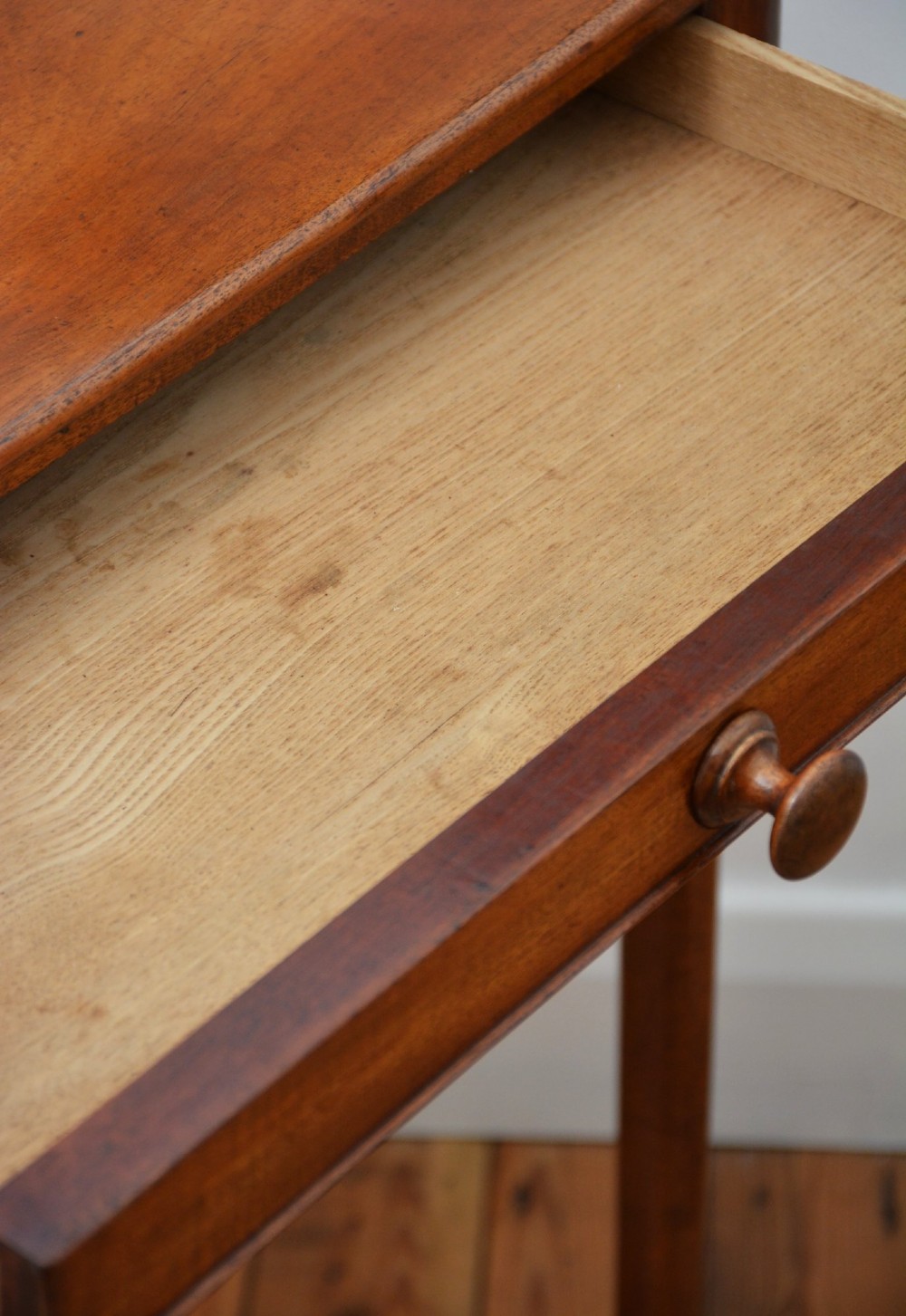 An English William IV mahogany side table featuring a single frieze drawer with a turned wooden knob handle and slim turned legs. View V