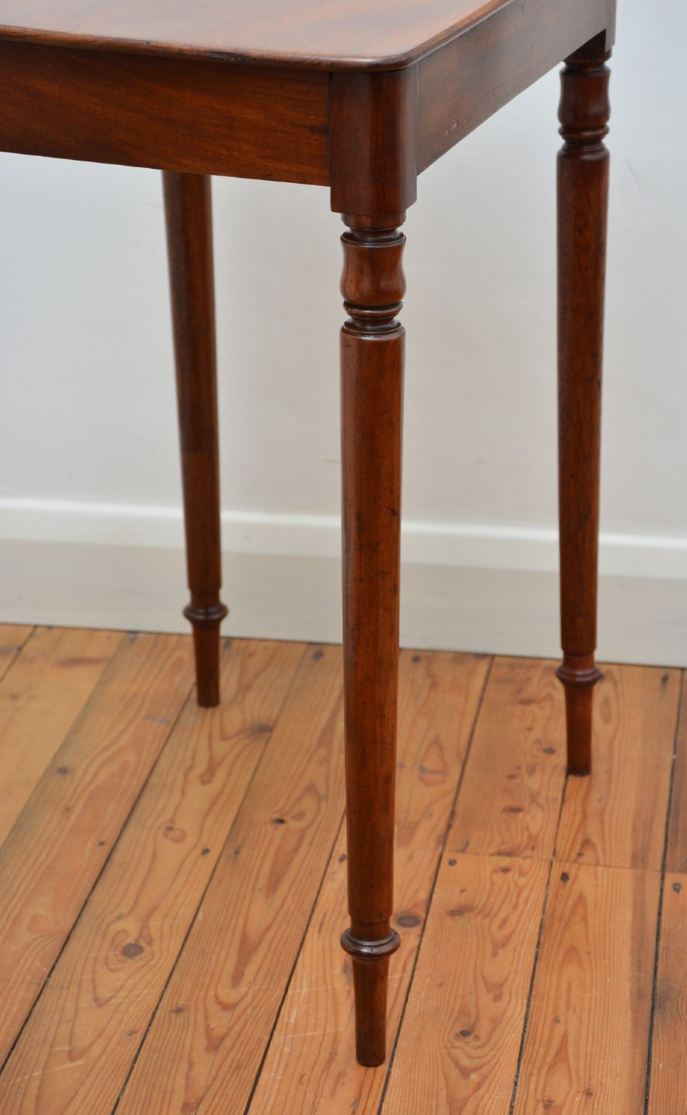 An English William IV mahogany side table featuring a single frieze drawer with a turned wooden knob handle and slim turned legs. View X