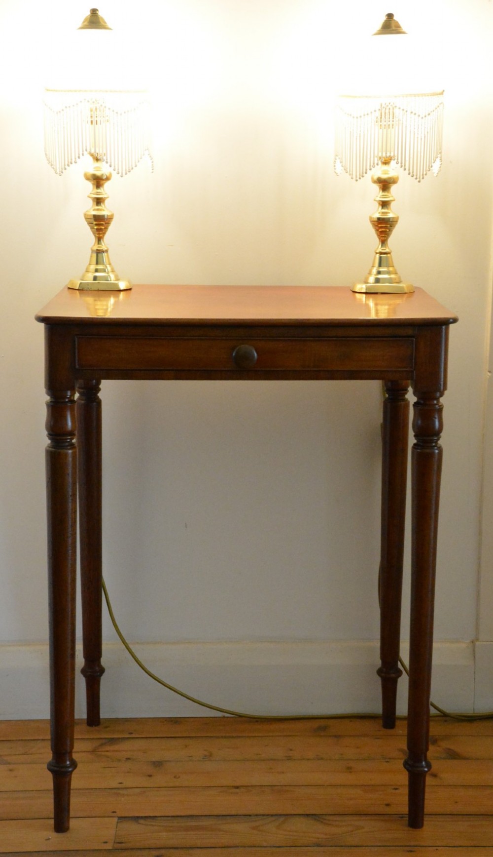 An English William IV mahogany side table featuring a single frieze drawer with a turned wooden knob handle and slim turned legs. View XII
