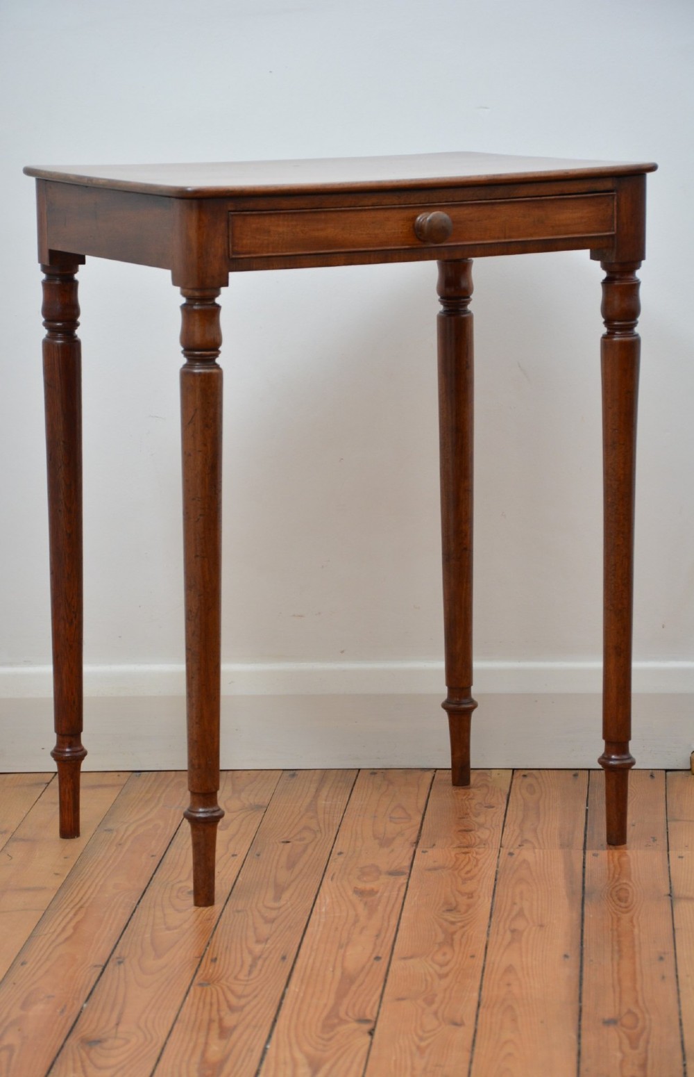 An English William IV mahogany side table featuring a single frieze drawer with a turned wooden knob handle and slim turned legs. View XIII