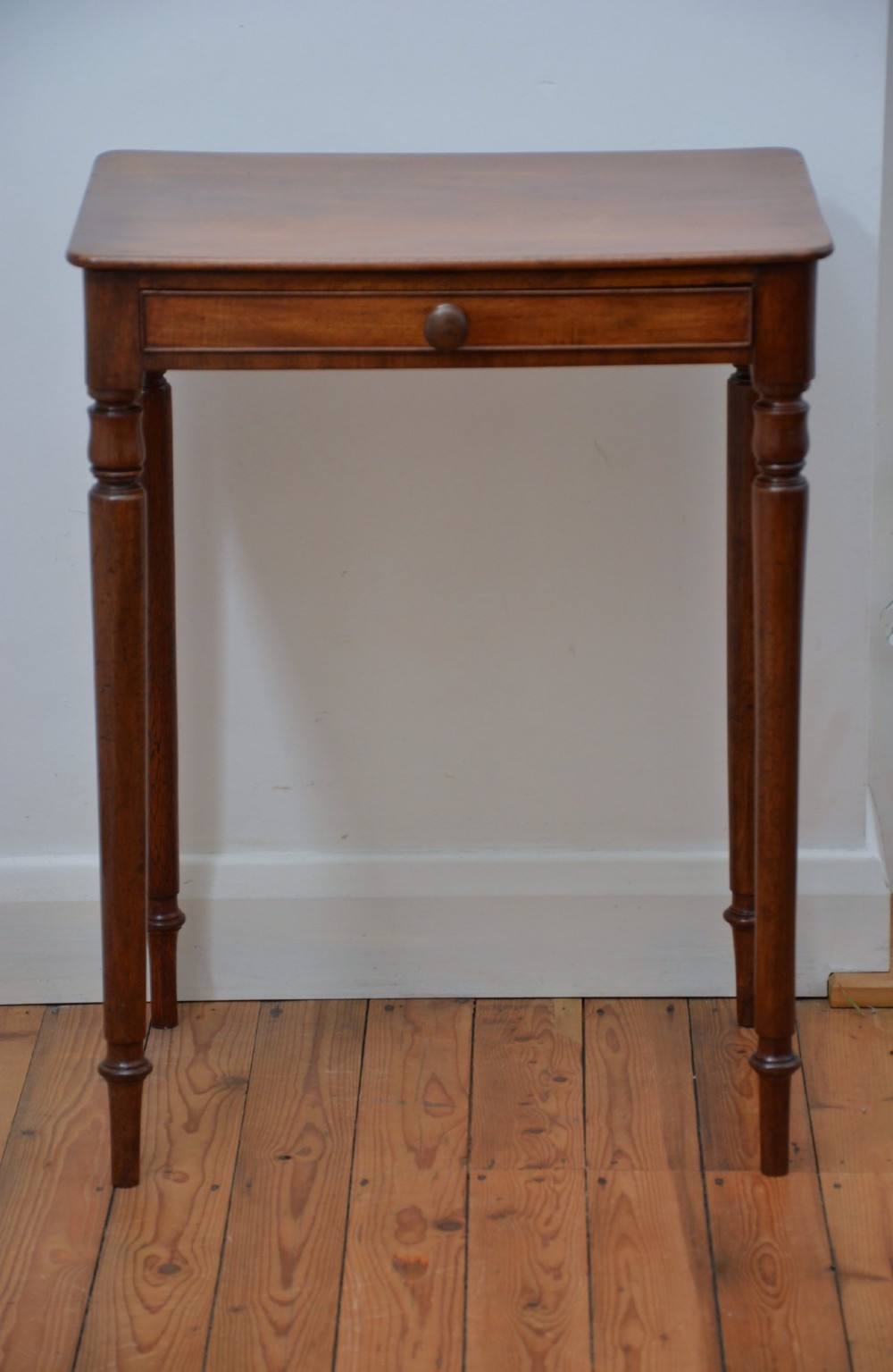 An English William IV mahogany side table featuring a single frieze drawer with a turned wooden knob handle and slim turned legs. View XIV