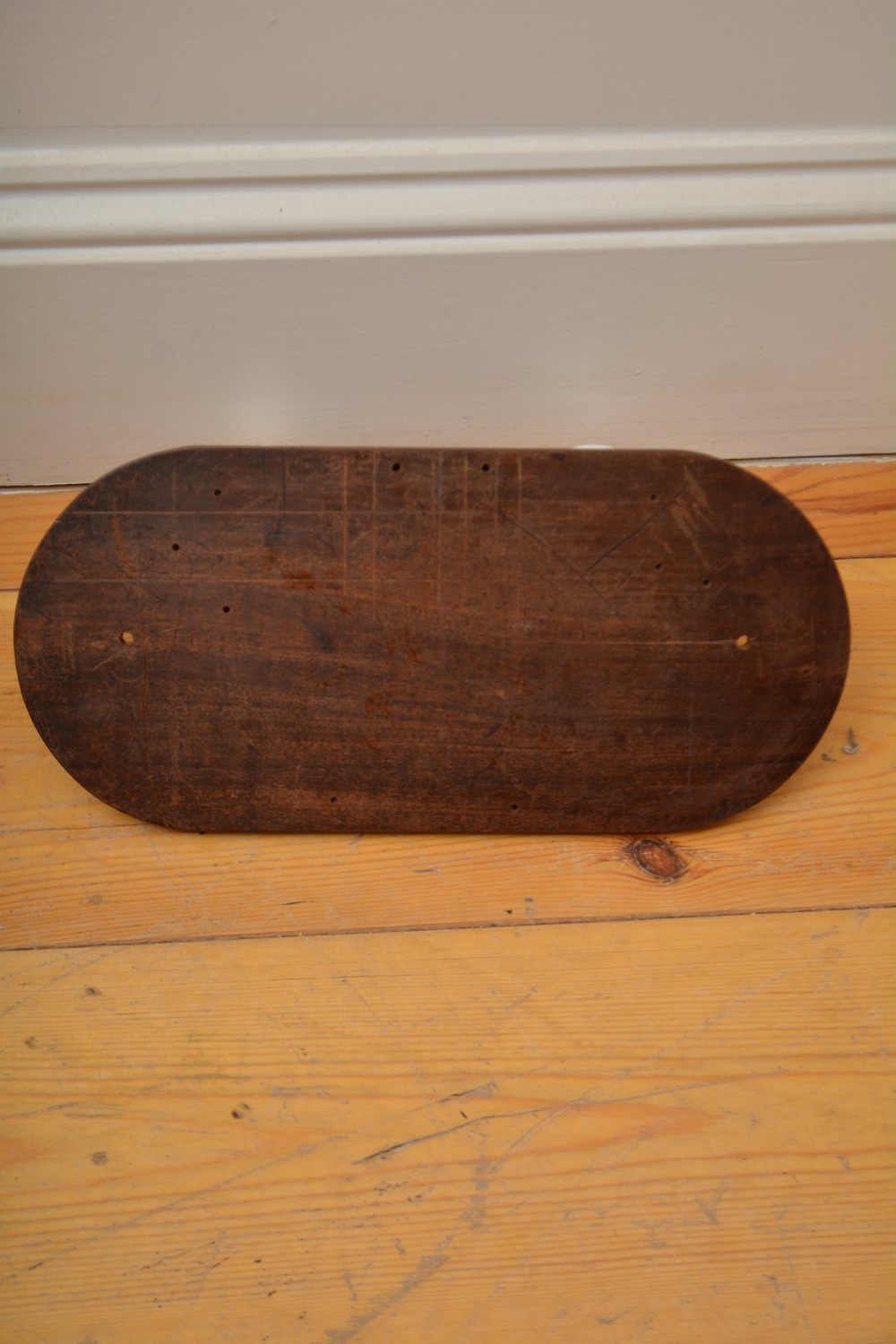 An oval mahogany wood backboard mounted with two twisted brass coat hooks featuring white ceramic end knobs. View II