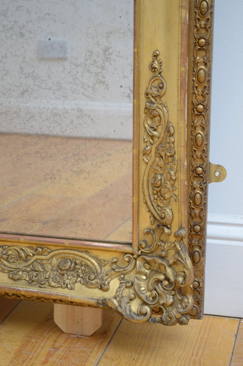 A tall rectangular floor-standing mirror with a gold-leaf gilded frame featuring intricate gesso moulding along the borders and corners. View II