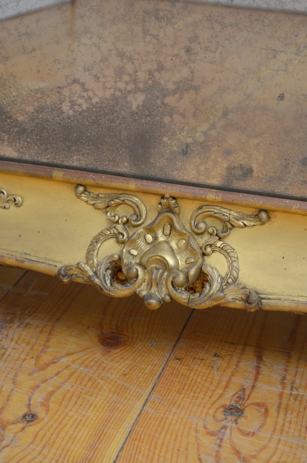 A tall rectangular floor-standing mirror with a gold-leaf gilded frame featuring intricate gesso moulding along the borders and corners. View IV