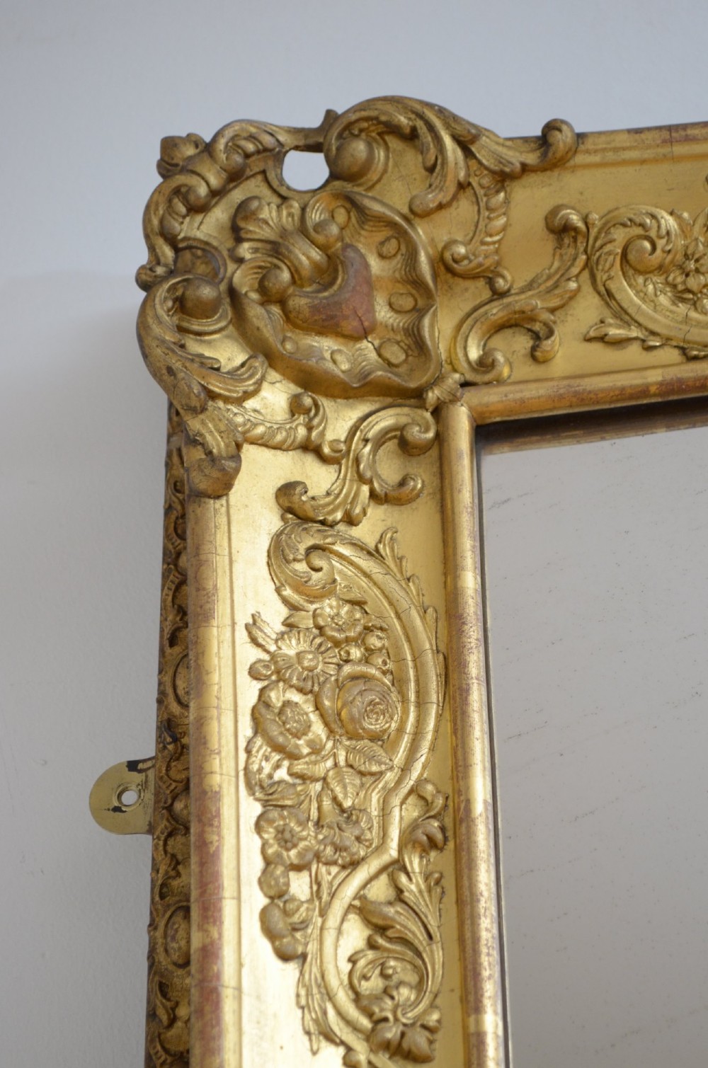 A tall rectangular floor-standing mirror with a gold-leaf gilded frame featuring intricate gesso moulding along the borders and corners. View X