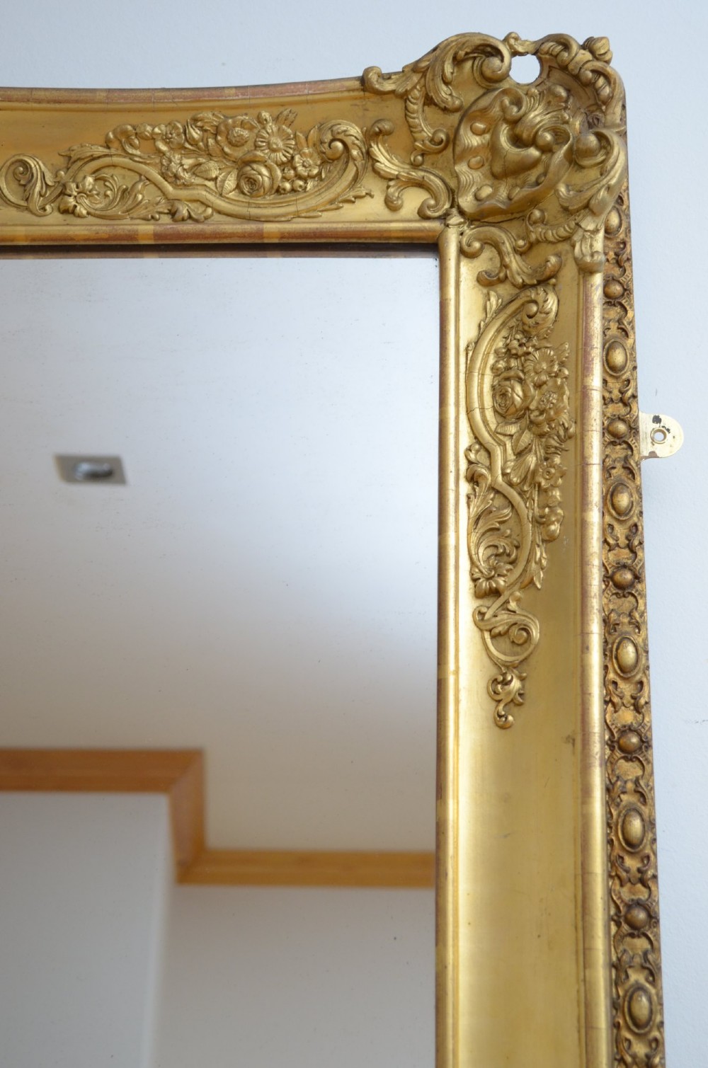 A tall rectangular floor-standing mirror with a gold-leaf gilded frame featuring intricate gesso moulding along the borders and corners. View XIII
