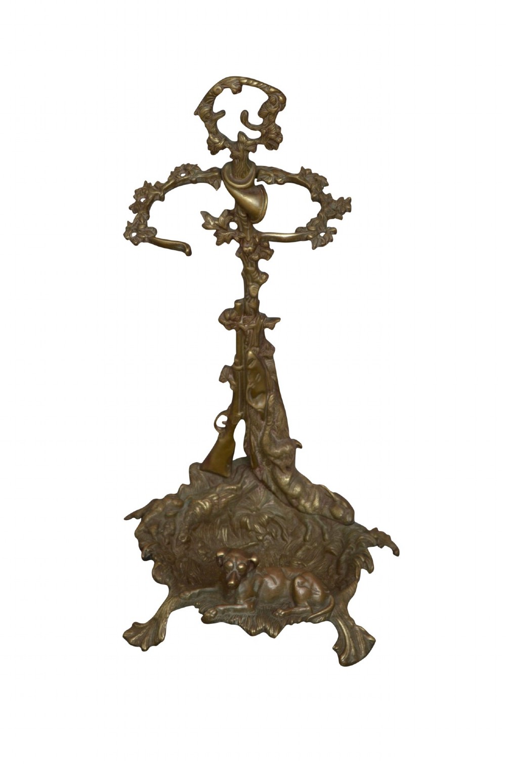 An antique cast brass stick stand featuring sporting motifs including a resting hound, rifle, game bag, and hunting horn.