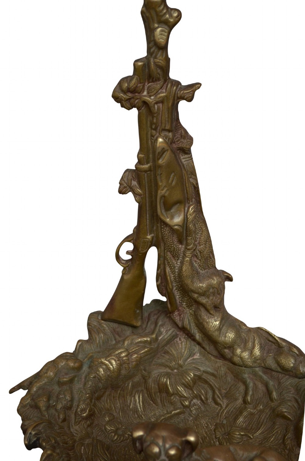 An antique cast brass stick stand featuring sporting motifs including a resting hound, rifle, game bag, and hunting horn. View V