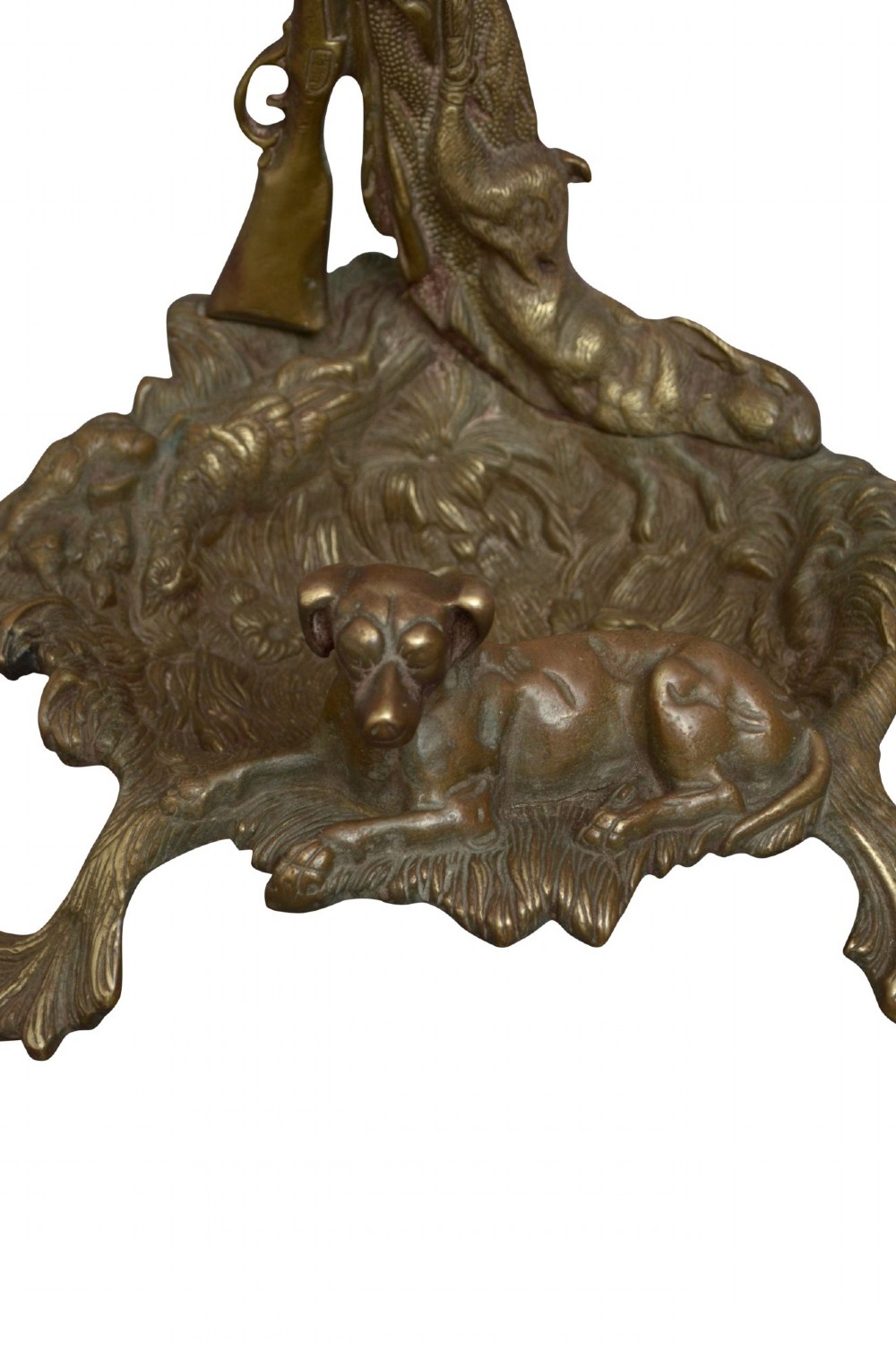 An antique cast brass stick stand featuring sporting motifs including a resting hound, rifle, game bag, and hunting horn. View VI