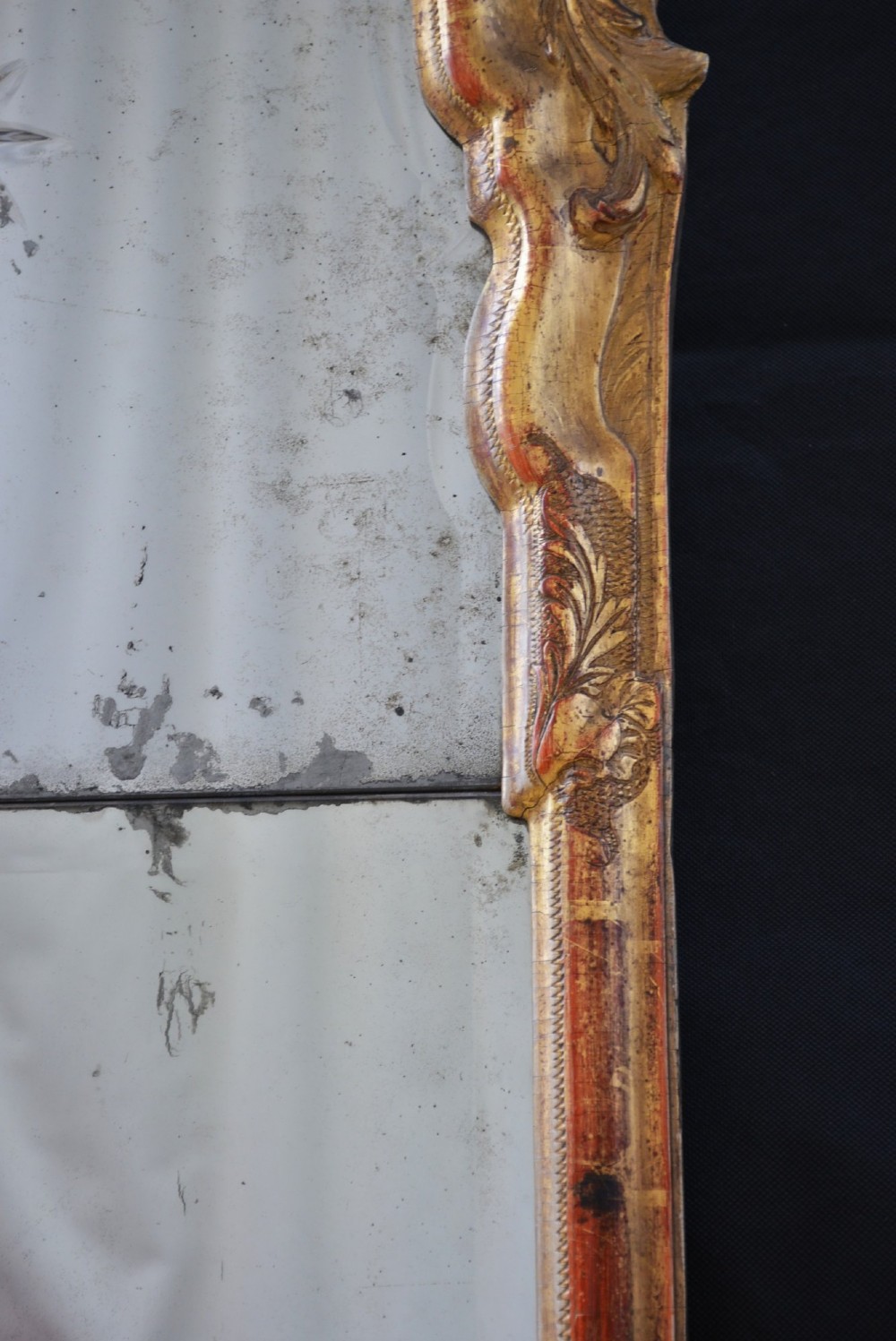A tall, narrow Georgian giltwood pier mirror featuring a carved shell crest, scrollwork frame, and a split glass mirror plate. View III