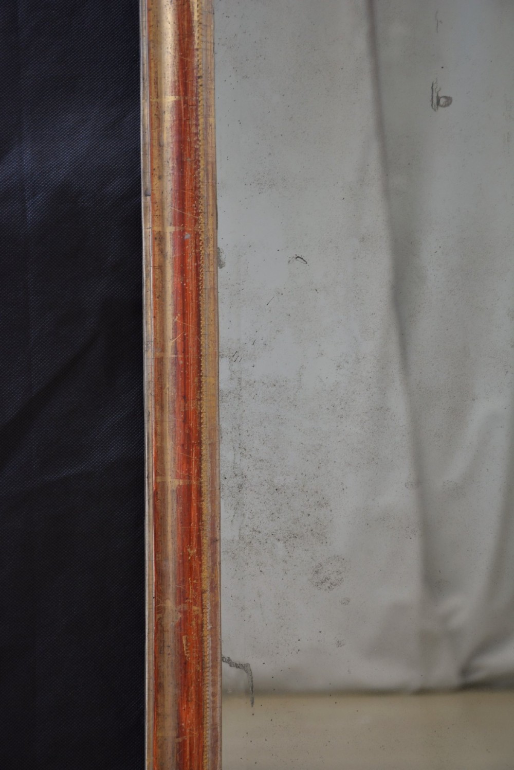 A tall, narrow Georgian giltwood pier mirror featuring a carved shell crest, scrollwork frame, and a split glass mirror plate. View IX
