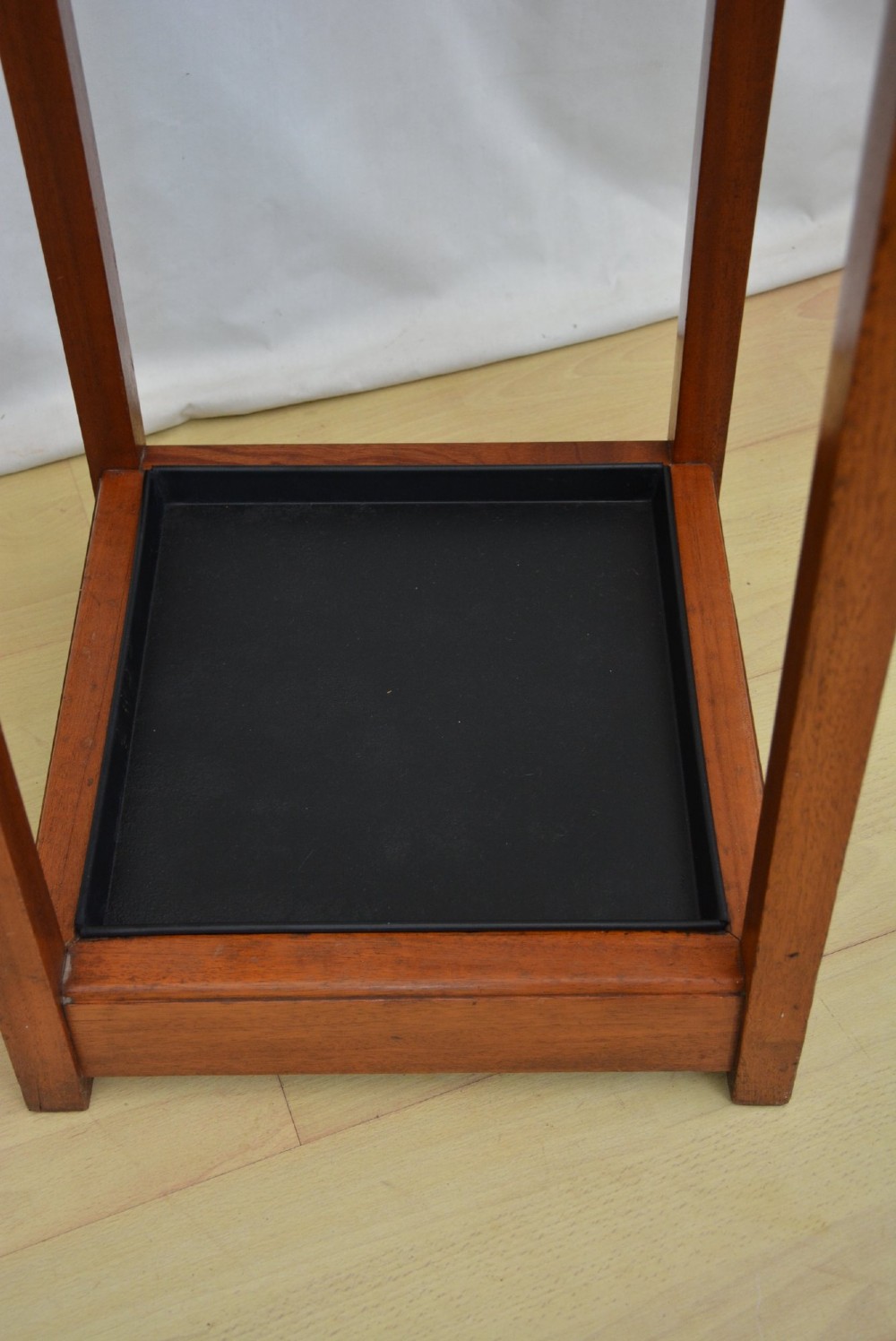 A tall, square-framed Art Deco wooden coat stand with dark metal hanging hooks and a lower umbrella drip tray. View XIII
