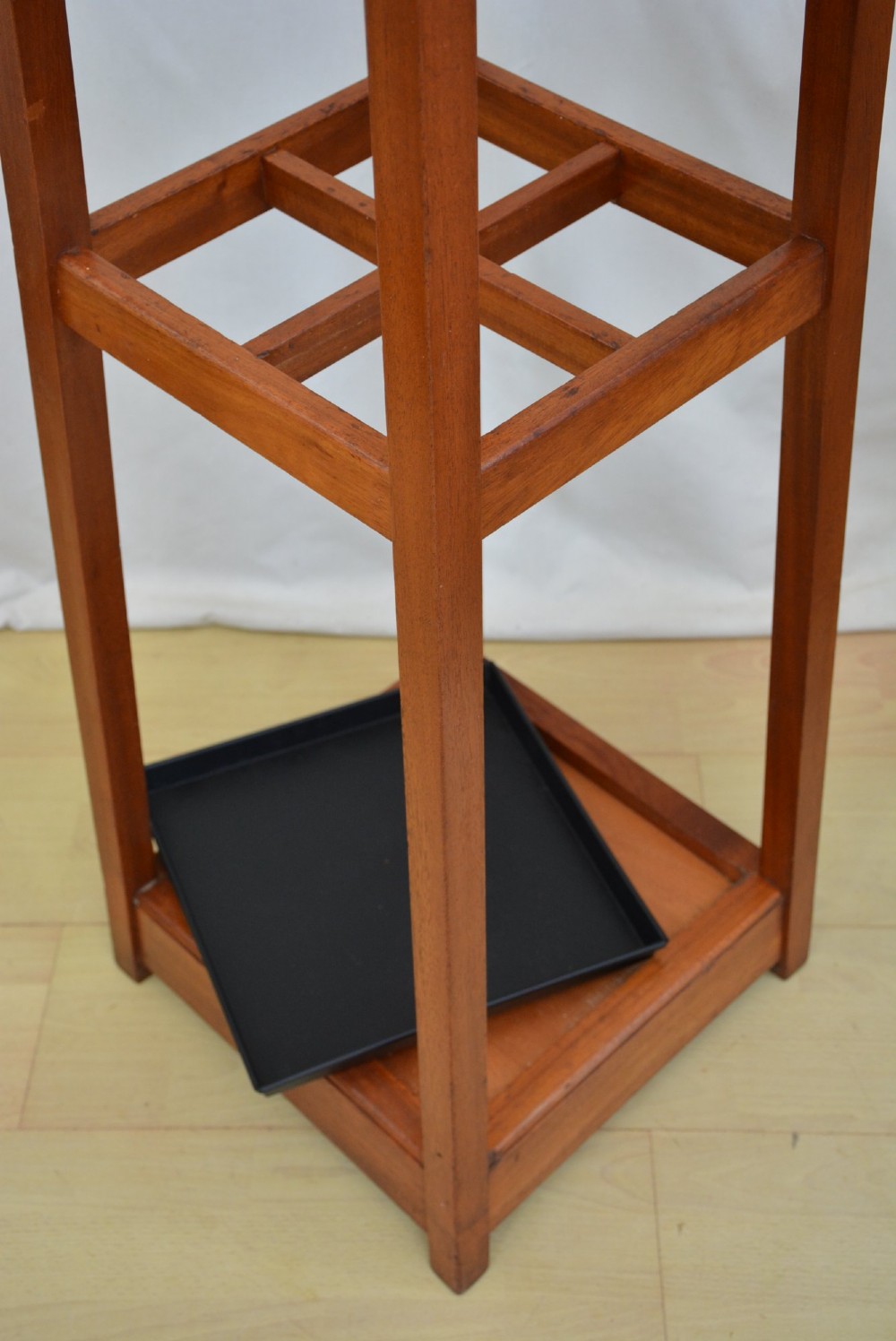 A tall, square-framed Art Deco wooden coat stand with dark metal hanging hooks and a lower umbrella drip tray. View XIV