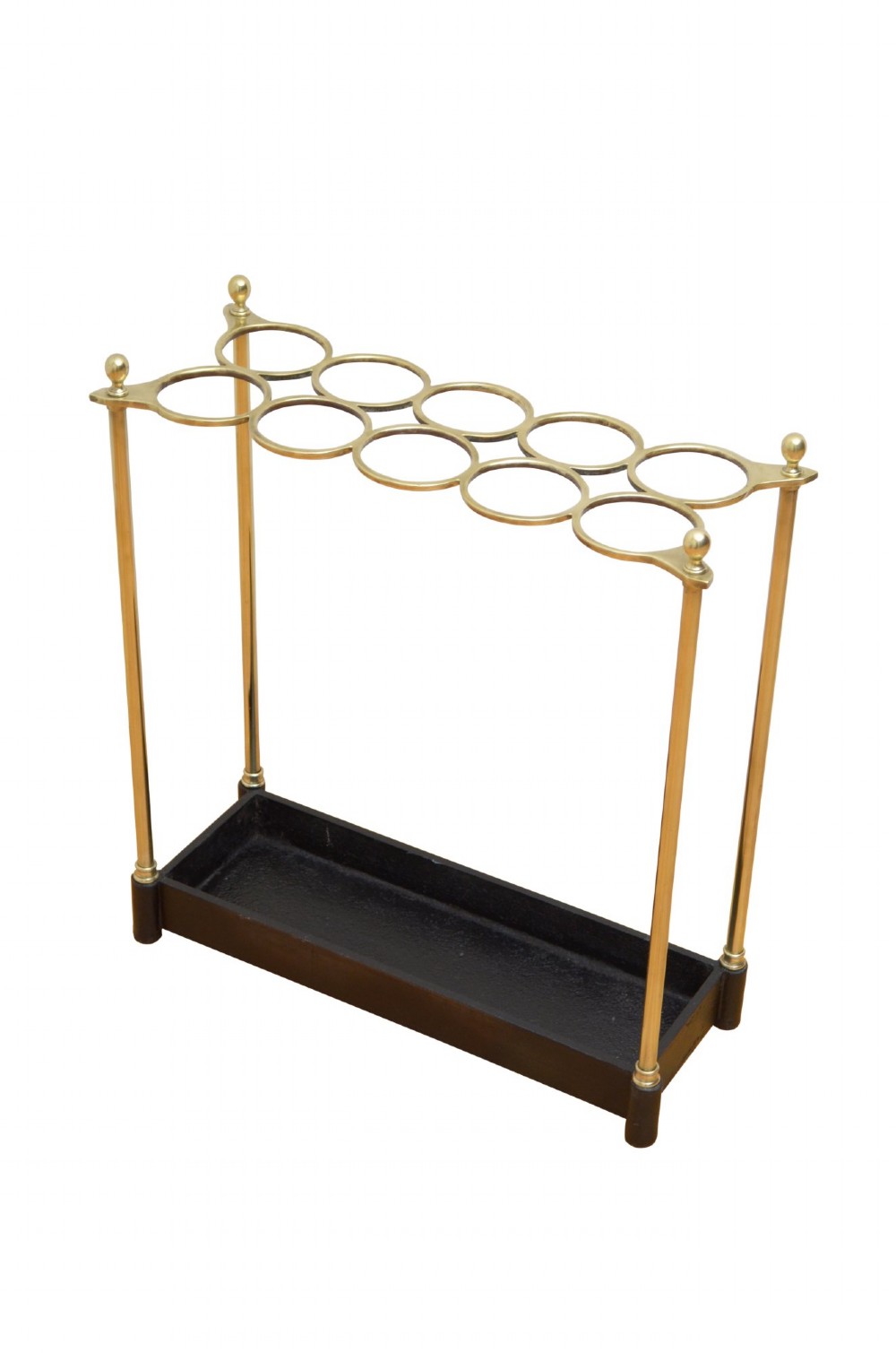 A Victorian brass umbrella stand featuring an eight-ring top frame, four tubular posts with ball finials, and a rectangular black cast iron drip tray.