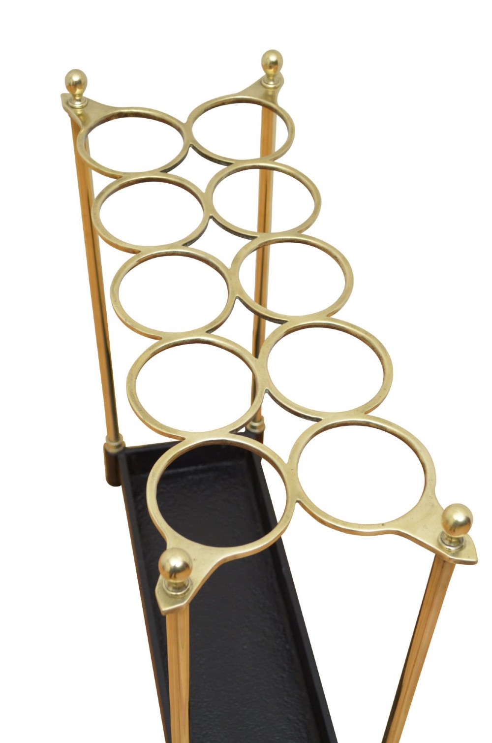 A Victorian brass umbrella stand featuring an eight-ring top frame, four tubular posts with ball finials, and a rectangular black cast iron drip tray. View II