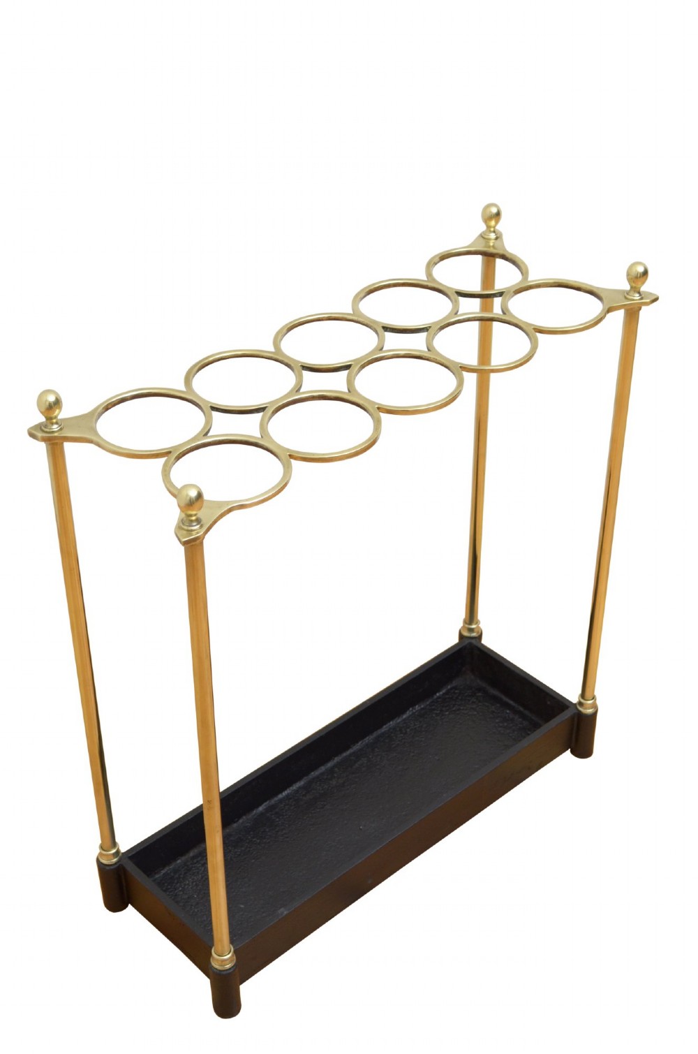 A Victorian brass umbrella stand featuring an eight-ring top frame, four tubular posts with ball finials, and a rectangular black cast iron drip tray. View VI