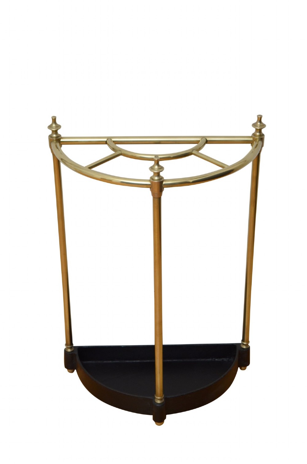 A semi-circular brass umbrella stand featuring vertical tubular supports, decorative finials, top divisions, and a black cast-iron drip tray base.